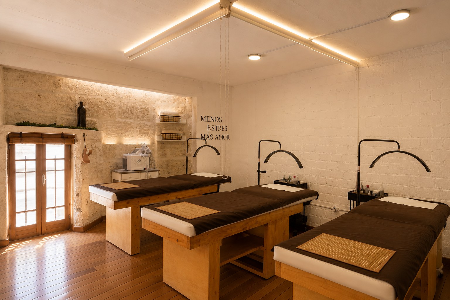 Sala de tratamiento con camillas de madera y muro de piedra sillar en HerStudio